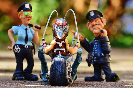 two police toys in front of man riding motorcycle toy thumbnail