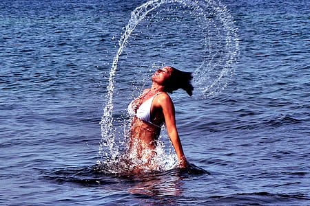woman on body of water wearing white bikini top thumbnail