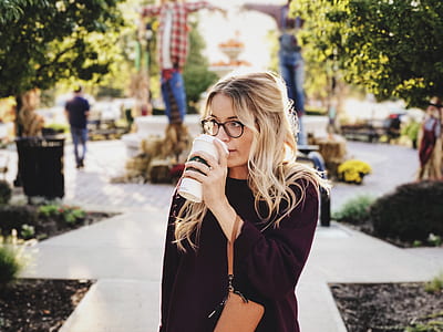woman wearing purple knit sweater holding white plastic travel cup during daytime thumbnail