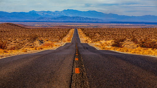 empty black concrete rode at distance to mountain ranges thumbnail