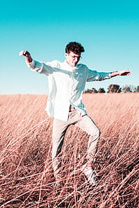 man standing in middle of brown grass field thumbnail