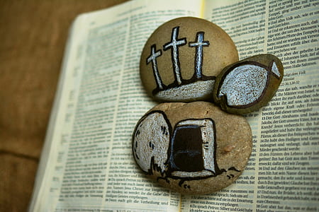 three stones with paint on top of bible thumbnail