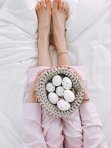 Woman Holding Gray Crochet Bowl With Seven Painted Eggs thumbnail