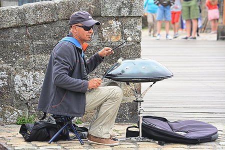 man sitting on folding chair holding drum stick thumbnail