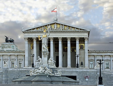 white concrete building under gray clouds during daytime thumbnail