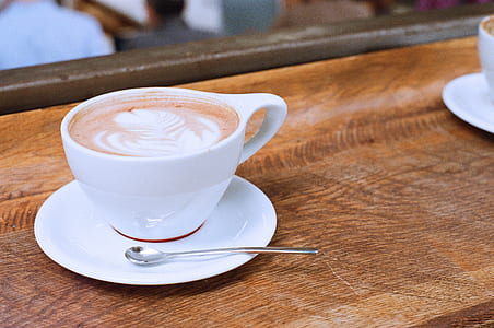 white mug filled with coffee on top of table thumbnail