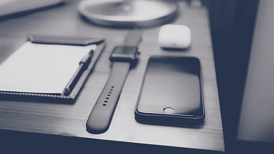 space gray iPhone 6 and space gray aluminum case Apple Watch on black table thumbnail