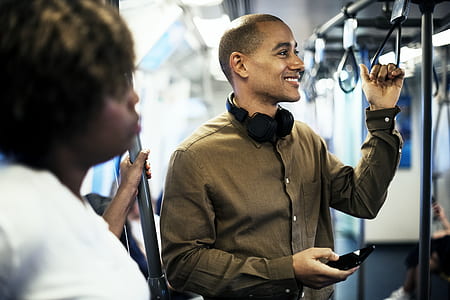 man standing inside the train holding hand grip thumbnail