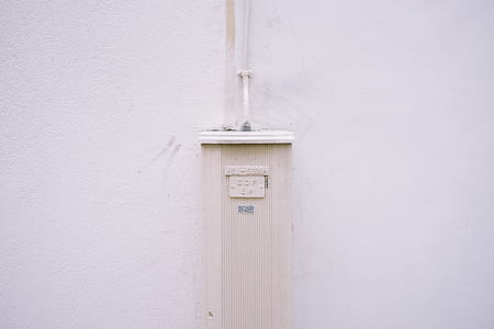 white corded electronic device on white painted wall thumbnail