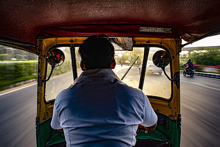 Man in Blue Shirt Driving Auto Rickshaw thumbnail
