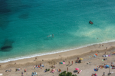 group of people on beach during daytime thumbnail