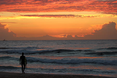 person walking on shore during golden hour thumbnail