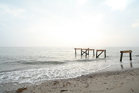 seashore with brown wooden stands under white sky thumbnail