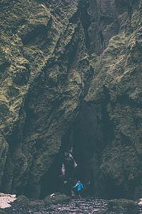 person wearing blue hoodie between rocks thumbnail