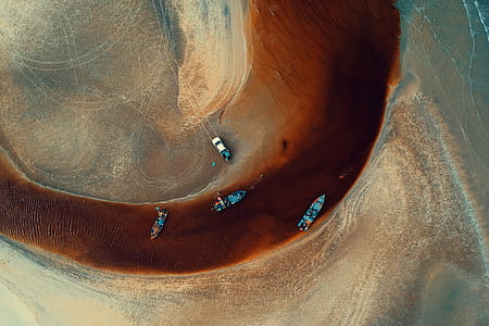 Aerial Photography of Four Blue Boats on Body of Water thumbnail