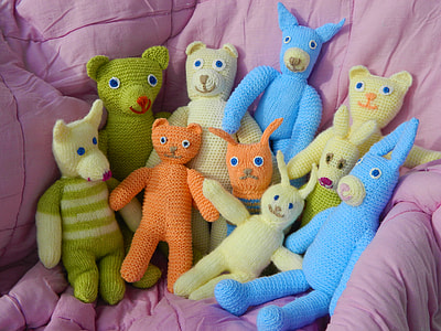 assorted knitted plush toys on pink comforter thumbnail