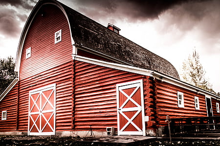 brown and black barn house under black clouds photo thumbnail