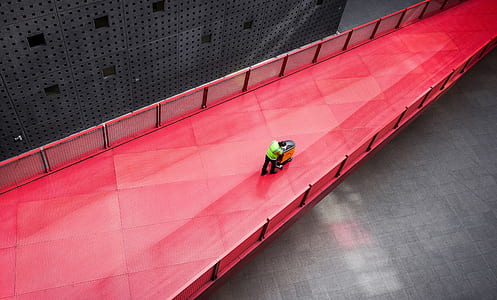 high angle photography of person pushing wagon in red bridge thumbnail