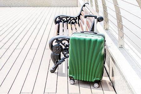 green travel luggage beside bench thumbnail