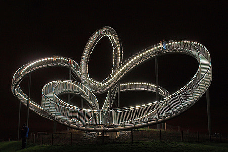 people standing on lighted spiral ladder during nighttime thumbnail