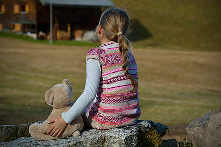 girl wearing pink and white tribal vest sitting on the rock thumbnail