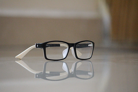 black and white framed eyeglasses on white surface thumbnail