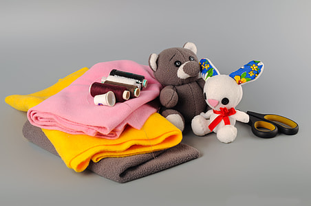two animal plush toys near assorted threads, scissors and cloths thumbnail