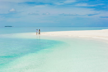 person walking on seashore during daytime thumbnail