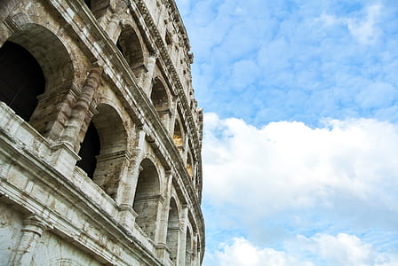 low angle photography of concrete building under cumulus clouds thumbnail