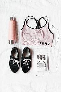 beige and black DKNY sports bra beside pink tumbler and black low-top sneakers thumbnail