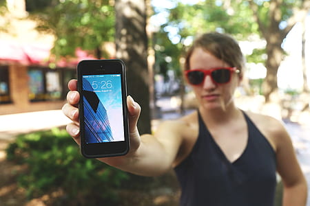 woman wearing black halter top holding black iPhone 5 thumbnail