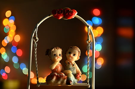 boy and girl sitting on swing figurine thumbnail
