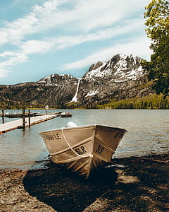 boat near body of water and mountains thumbnail