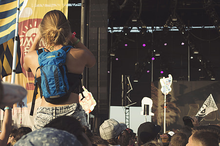 woman piggyback ride wearing blue backpack near stage thumbnail