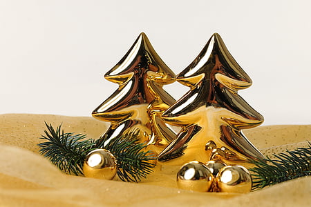 two gold-colored Christmas tree decors on sand thumbnail