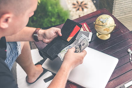 person holding wallet and banknotes thumbnail