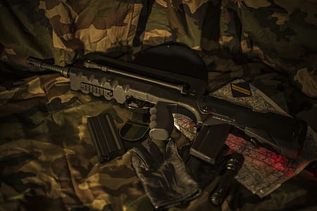 black assault rifle on woodland camouflage fabric surface thumbnail