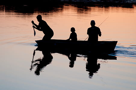 silhouette photography of three person riding boat thumbnail