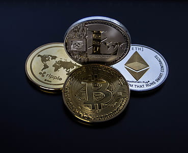 four Cryptocurrency coins placed on black surface thumbnail