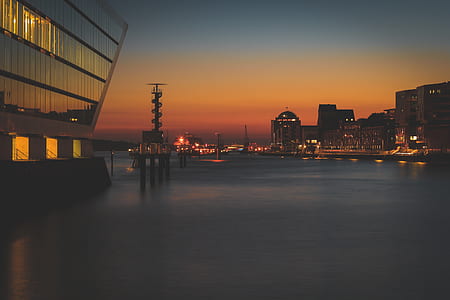 body of water and high rise buildings during sunset thumbnail
