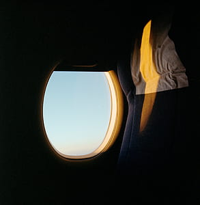 empty gray airline seat near window during day time thumbnail