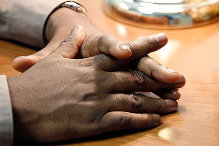 person's hand on brown wooden table thumbnail
