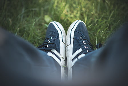 selective focus photograph of person wearing black-and-white shoes on grass thumbnail