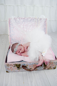 baby wearing white tutu skirt and silver alice band in a luggage photo session thumbnail