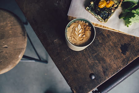 brown coffee inside white ceramic mug in top view photography thumbnail
