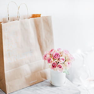 pink rose beside brown paper bag on top of table thumbnail