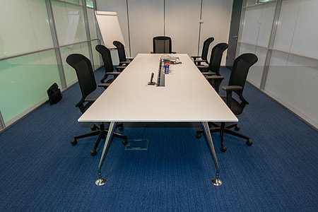 empty white long table with black rolling chairs thumbnail