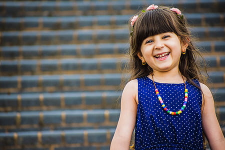 shallow focus on girl in blue and white sleeveless top while smiling thumbnail