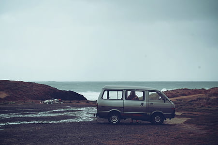 gray van near mountains and body of water during daytime thumbnail