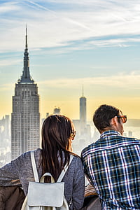woman standing beside man near buildings during daytime thumbnail